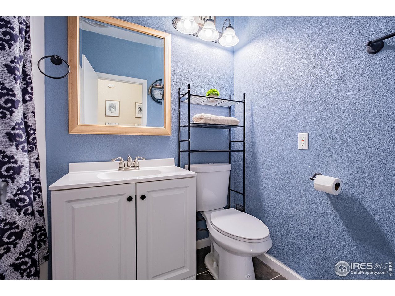 428 Douglas Street Sterling, CO 80751 - Photo 10 of 14 a bathroom with a toilet a sink and mirror