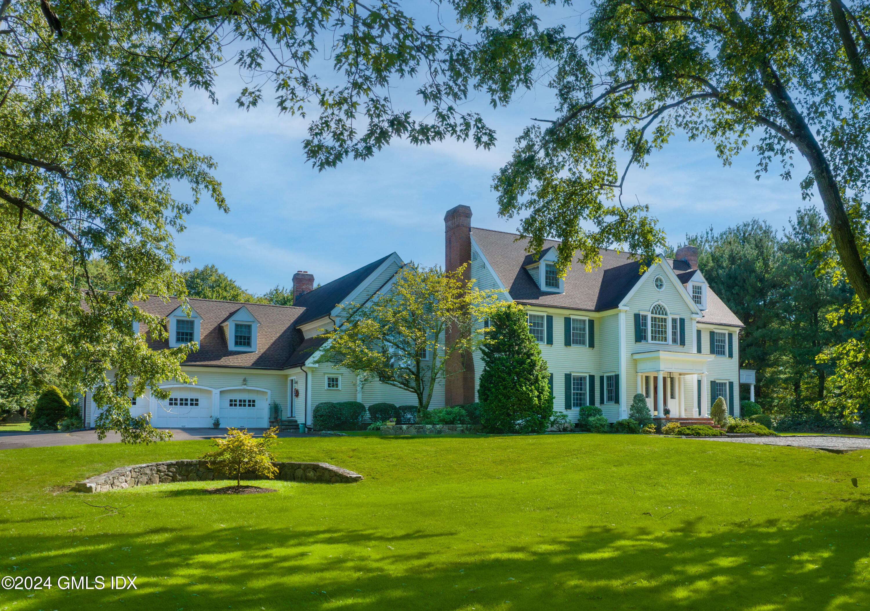 719 Ponus Ridge Road New Canaan, CT 06840 - Photo 1 of 38 a front view of a house with garden