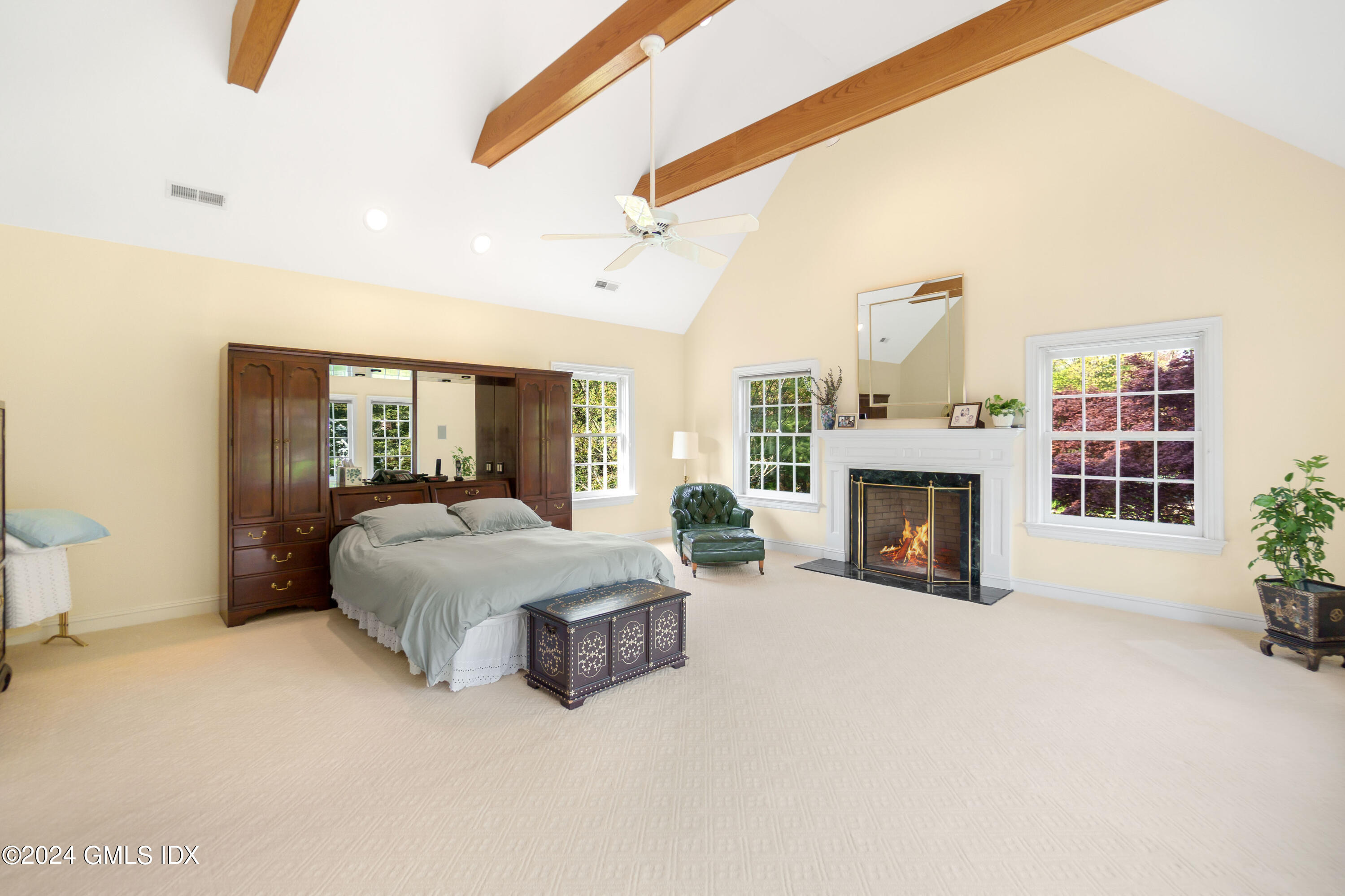 719 Ponus Ridge Road New Canaan, CT 06840 - Photo 13 of 38 a spacious bedroom with a balcony a bed and a fireplace