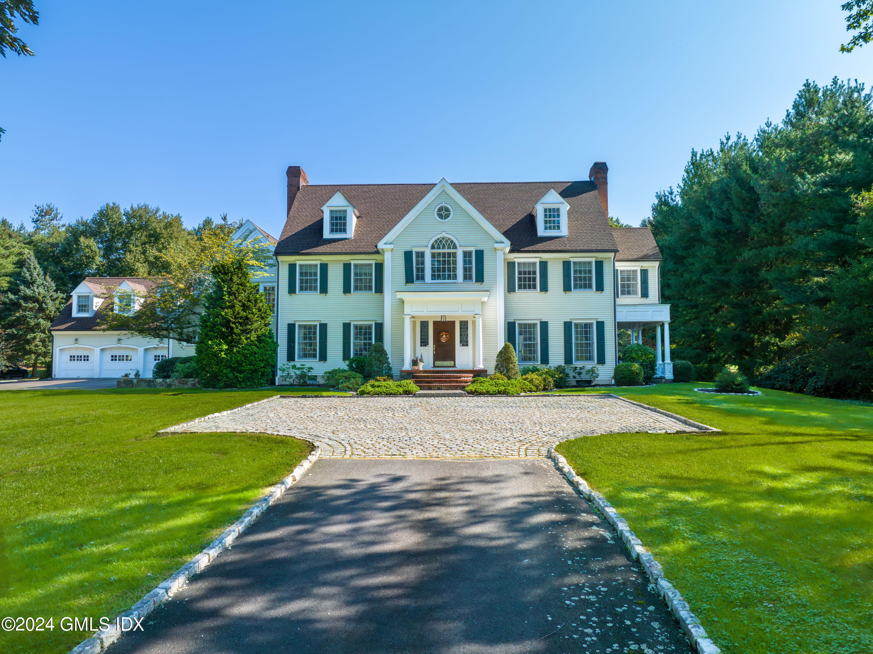 719 Ponus Ridge Road New Canaan, CT 06840 - Photo 28 of 38 a front view of a house with a big yard and potted plants