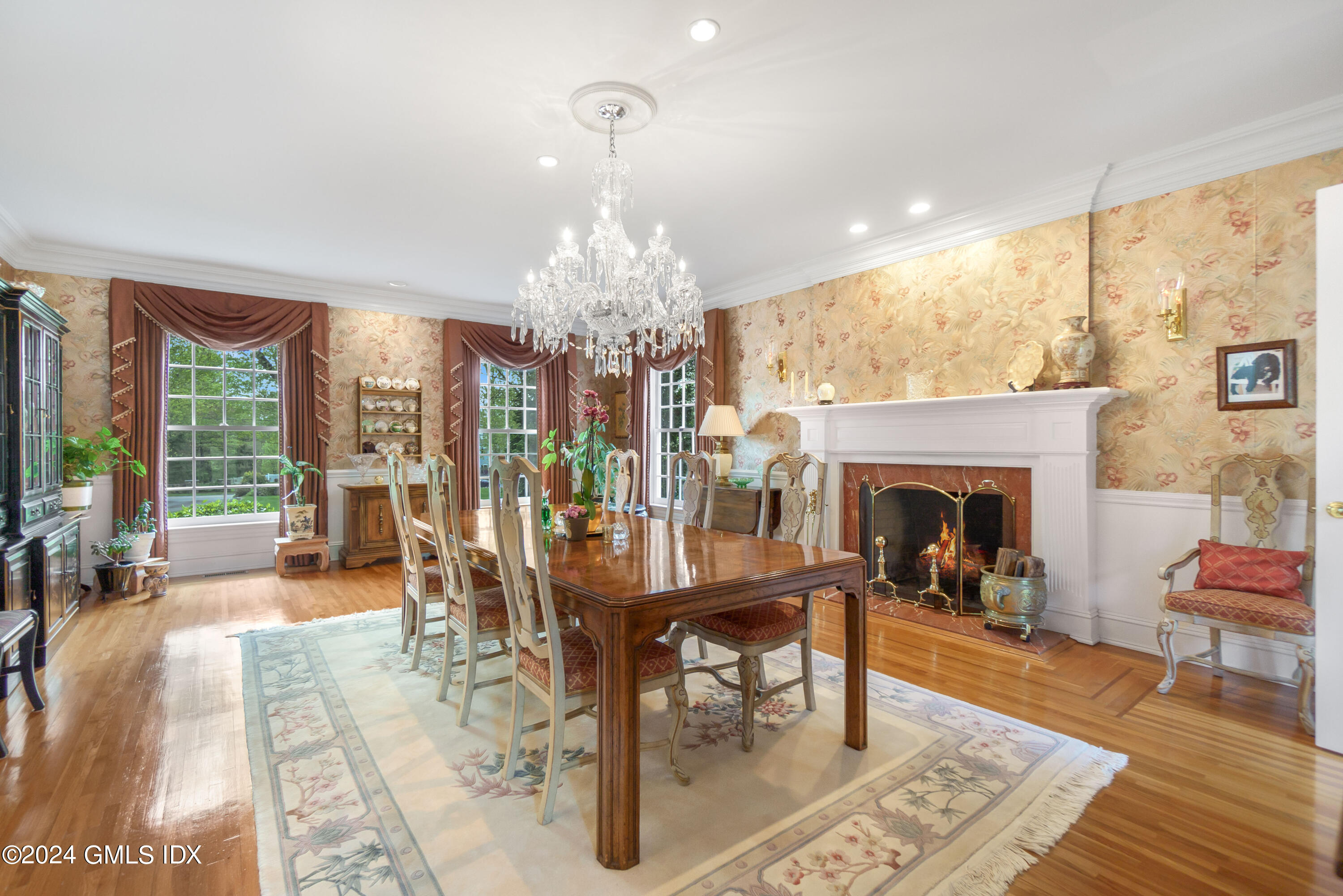 719 Ponus Ridge Road New Canaan, CT 06840 - Photo 8 of 38 a living room with furniture a chandelier and a fireplace