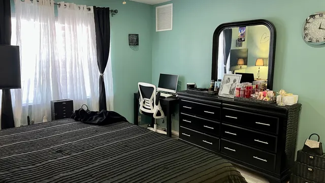 a bedroom with a bed and a mirror on dresser