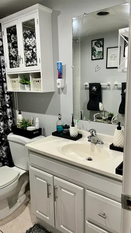 a bathroom with a granite countertop sink mirror and toilet