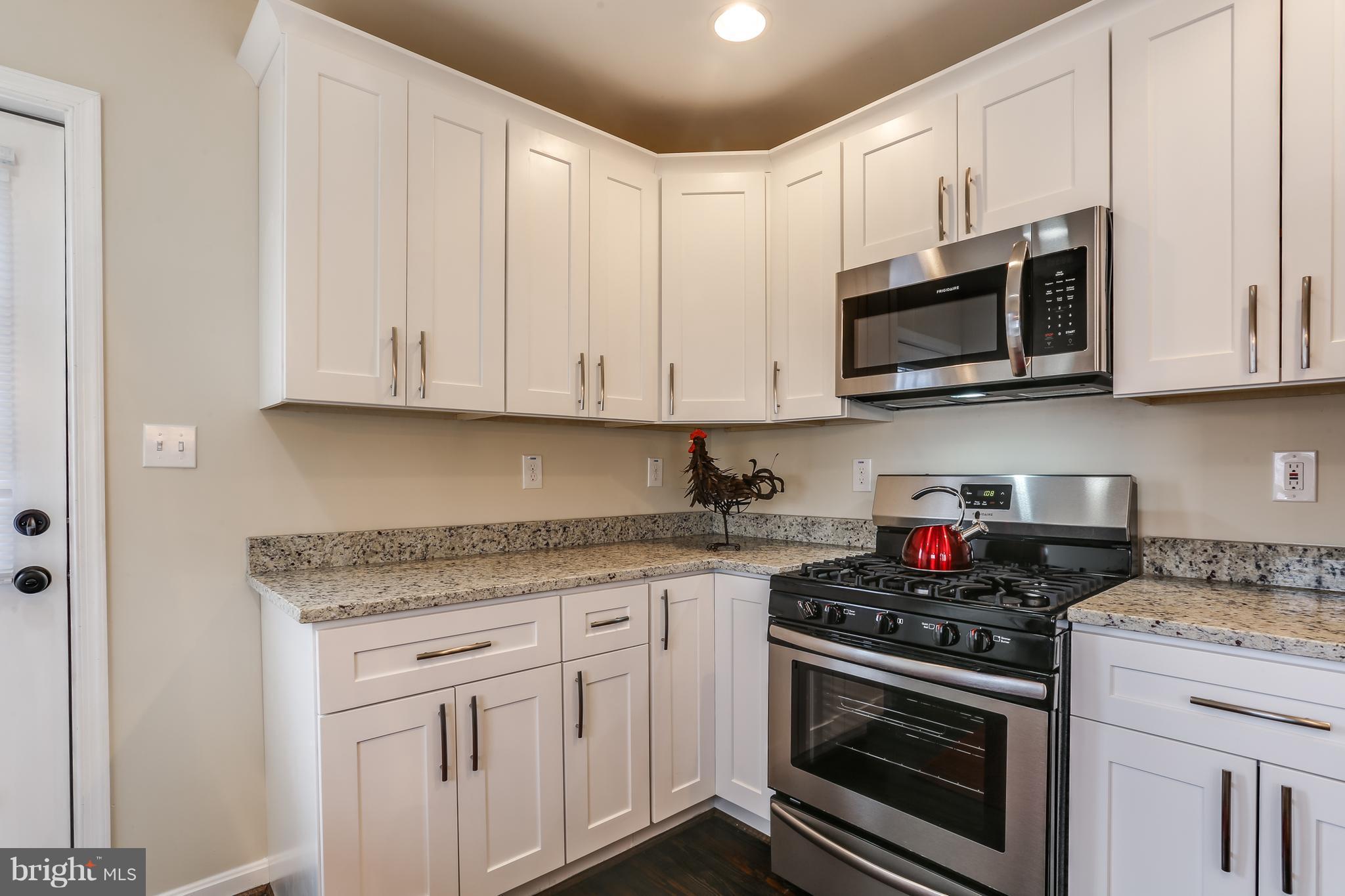 7907 Underhill Road Baltimore, MD 21237 - Photo 14 of 27 a kitchen with stainless steel appliances granite countertop grey cabinets a stove a sink and dishwasher