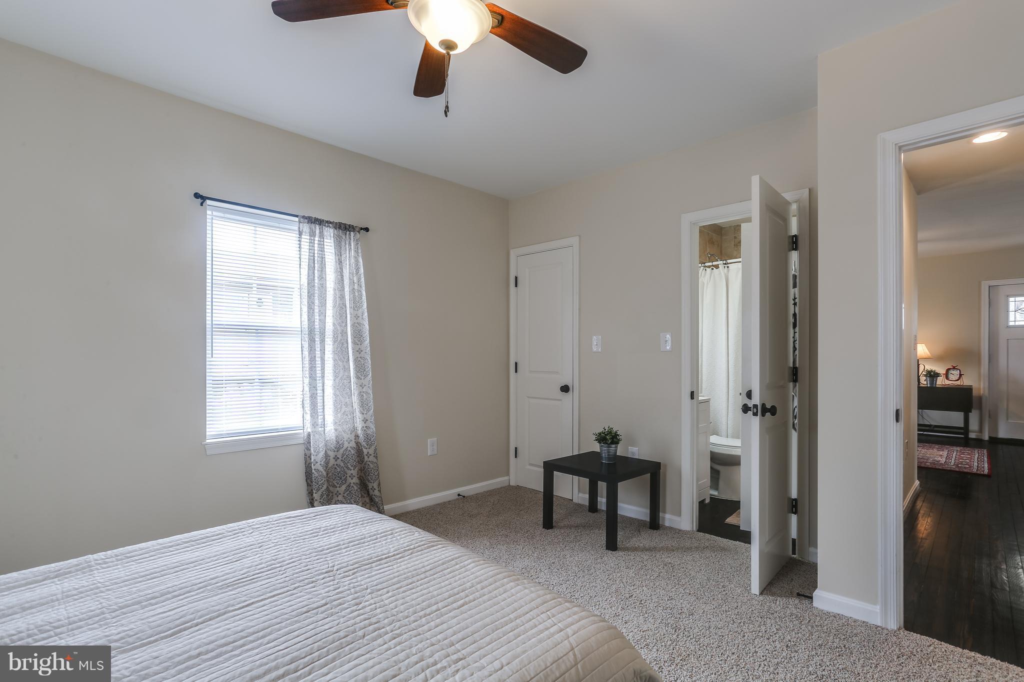 7907 Underhill Road Baltimore, MD 21237 - Photo 16 of 27 a spacious bedroom with a bed and a chandelier