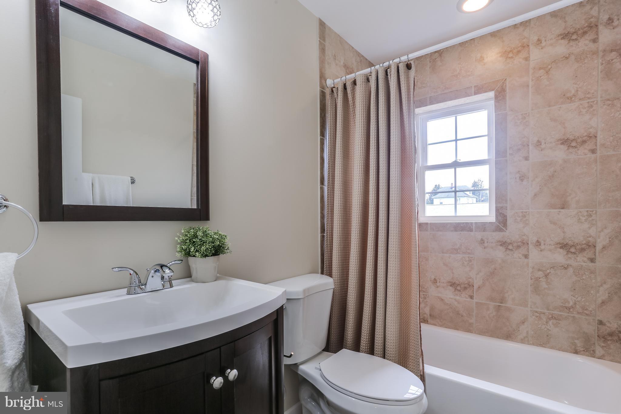 7907 Underhill Road Baltimore, MD 21237 - Photo 22 of 27 a bathroom with a sink a toilet and shower