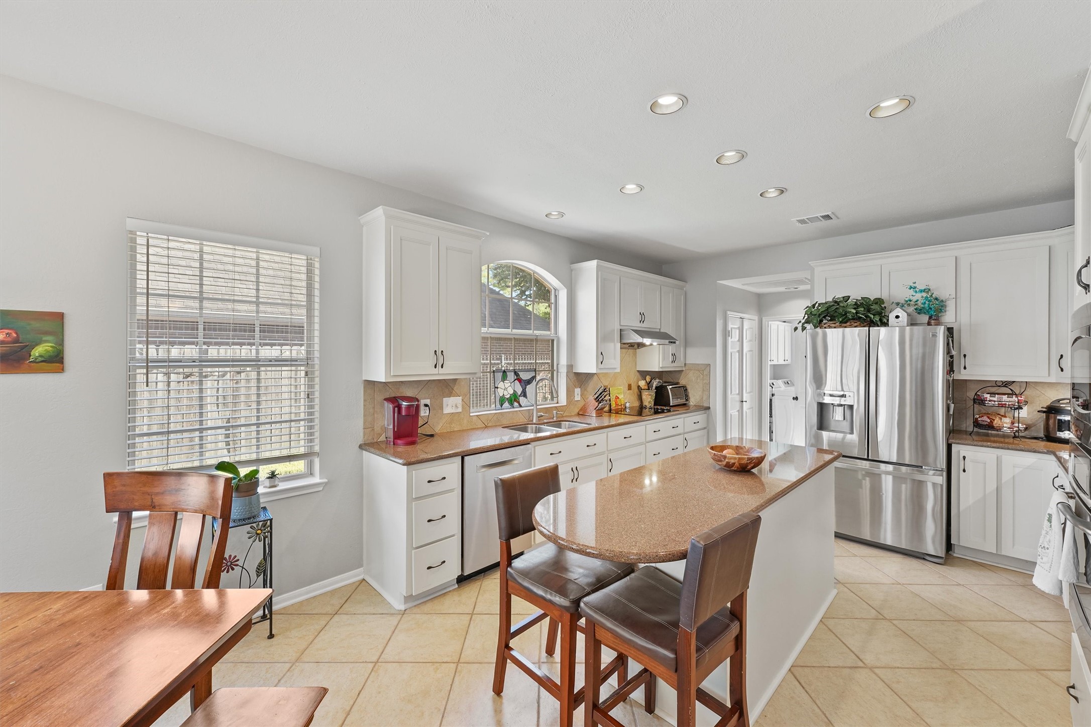 3006 Rothbury Drive Pearland, TX 77584 - Photo 11 of 28 a kitchen with stainless steel appliances a stove a refrigerator a table and chairs