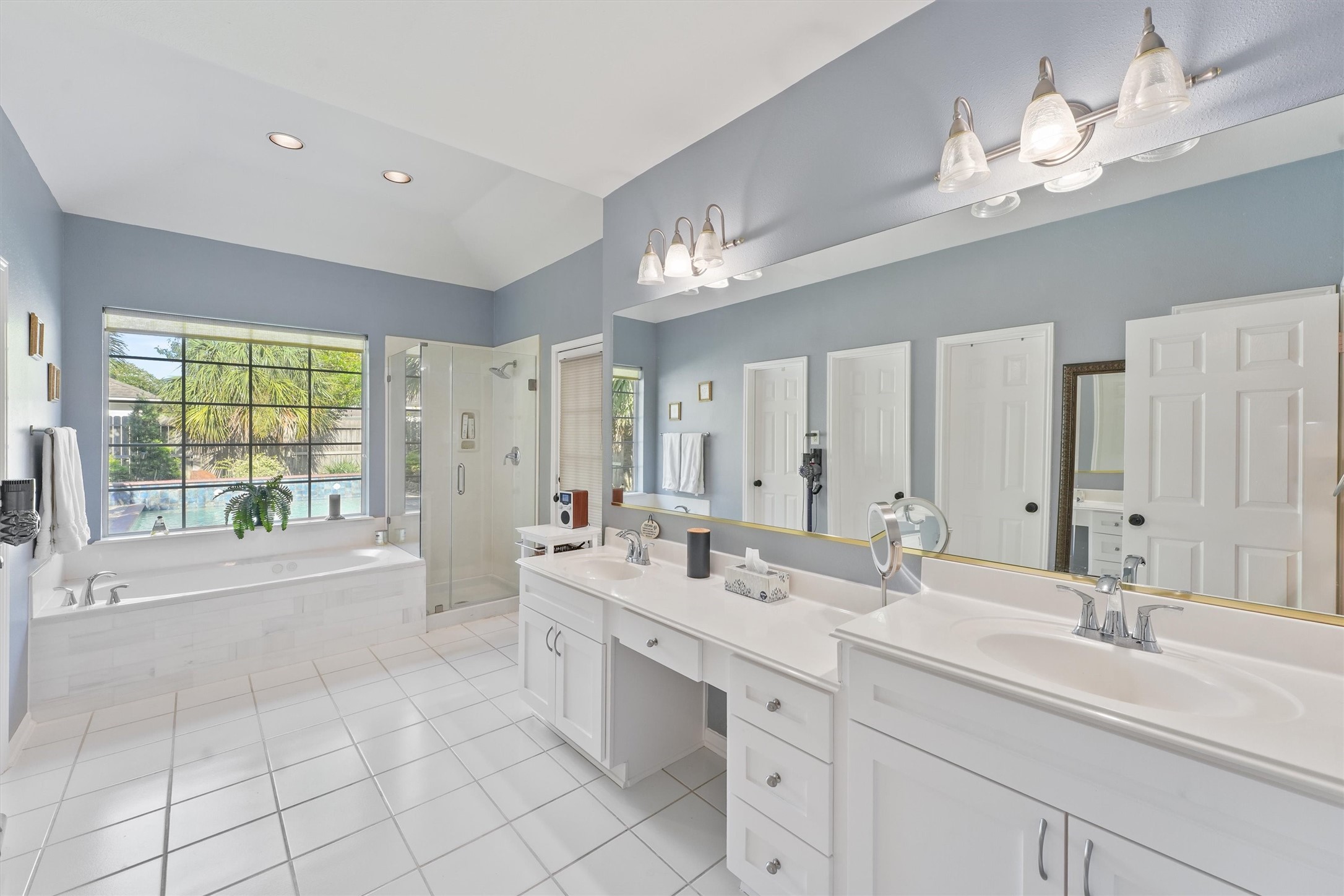 3006 Rothbury Drive Pearland, TX 77584 - Photo 14 of 28 a bathroom with a double vanity sink a large mirror and a bathtub