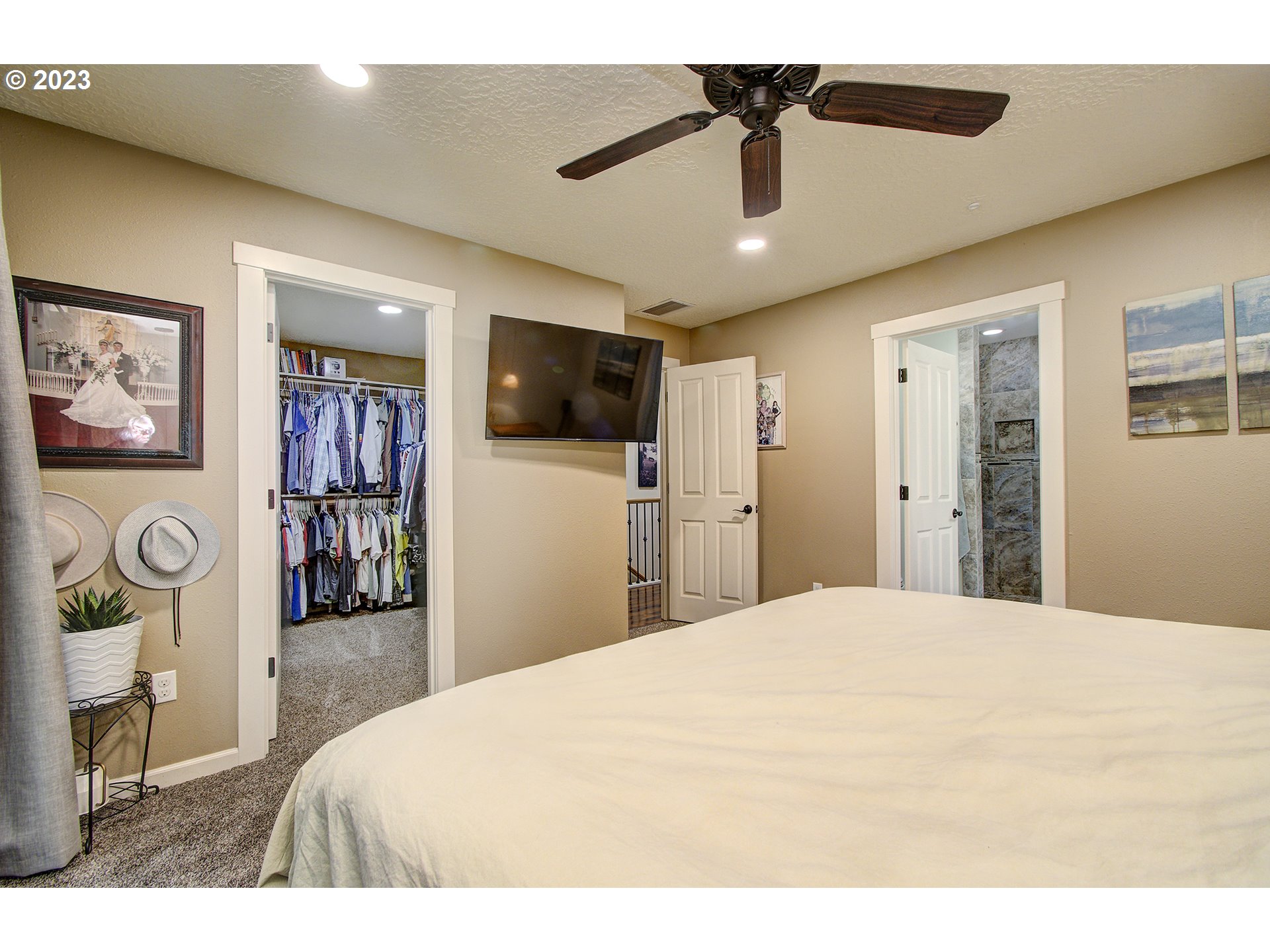 13025 Northeast Prairie Road Brush Prairie, WA 98606 - Photo 19 of 47 a large bedroom with a bed and a flat screen tv