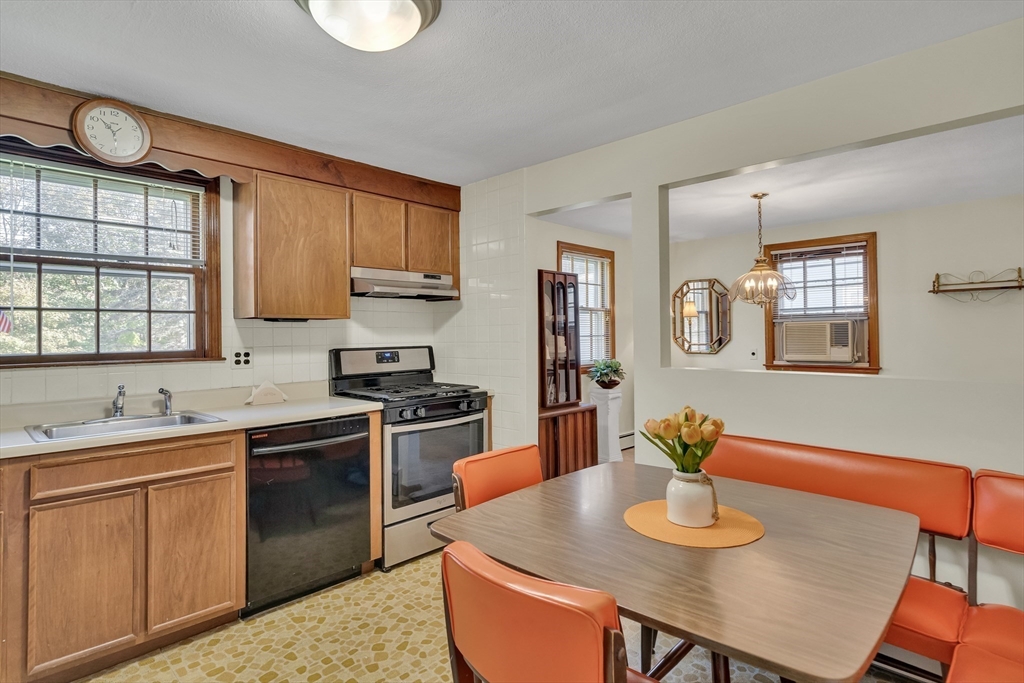 42 Grapevine Avenue Lexington, MA 02421 - Photo 13 of 36 a kitchen with stainless steel appliances granite countertop a stove a sink dishwasher a dining table and chairs with wooden floor