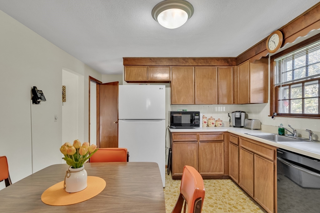 42 Grapevine Avenue Lexington, MA 02421 - Photo 15 of 36 a kitchen with stainless steel appliances granite countertop a sink refrigerator stove and microwave