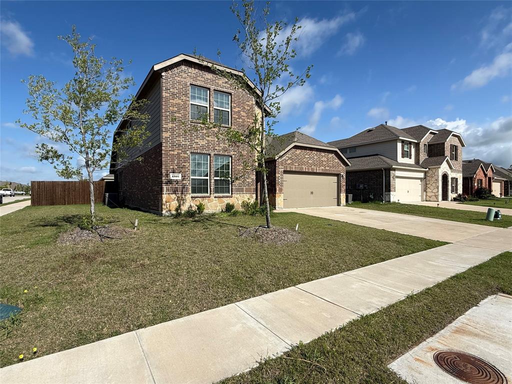 1306 Colonial Bluff Lane Princeton, TX 75407 - Photo 3 of 27 Brick and stone facade residence with a two-car garage, featuring a private fenced yard and a sidewalk entry