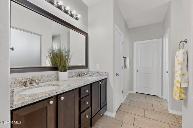 a bathroom with a granite countertop sink and a mirror