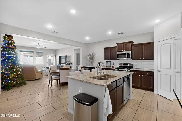 a kitchen with granite countertop a sink stove and refrigerator