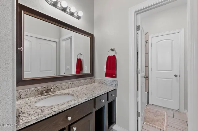 a bathroom with a granite countertop sink and a mirror