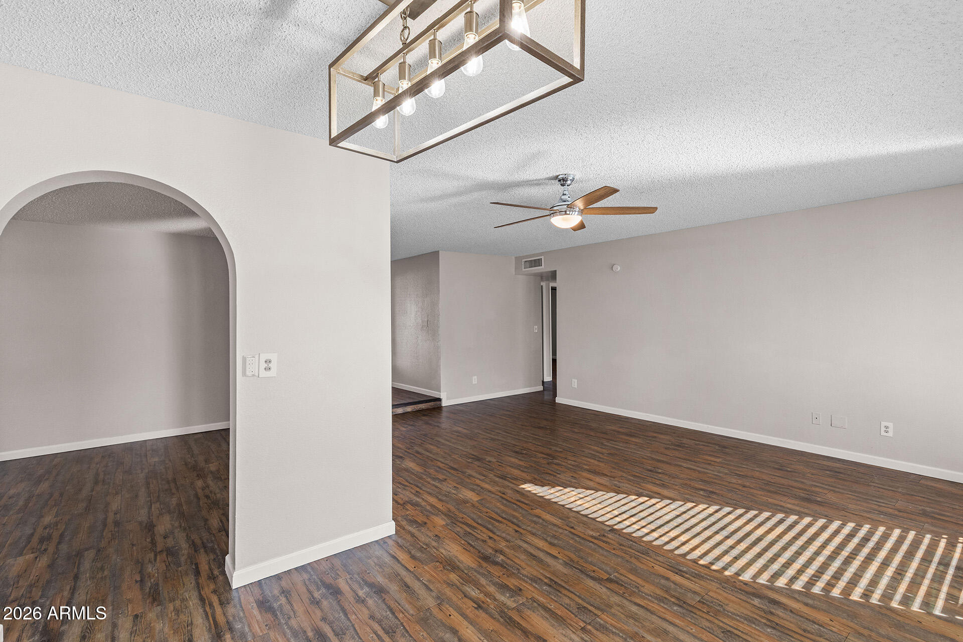 7267 West Charter Oak Road Peoria, AZ 85381 - Photo 11 of 45 a view of a livingroom with wooden floor and a ceiling fan