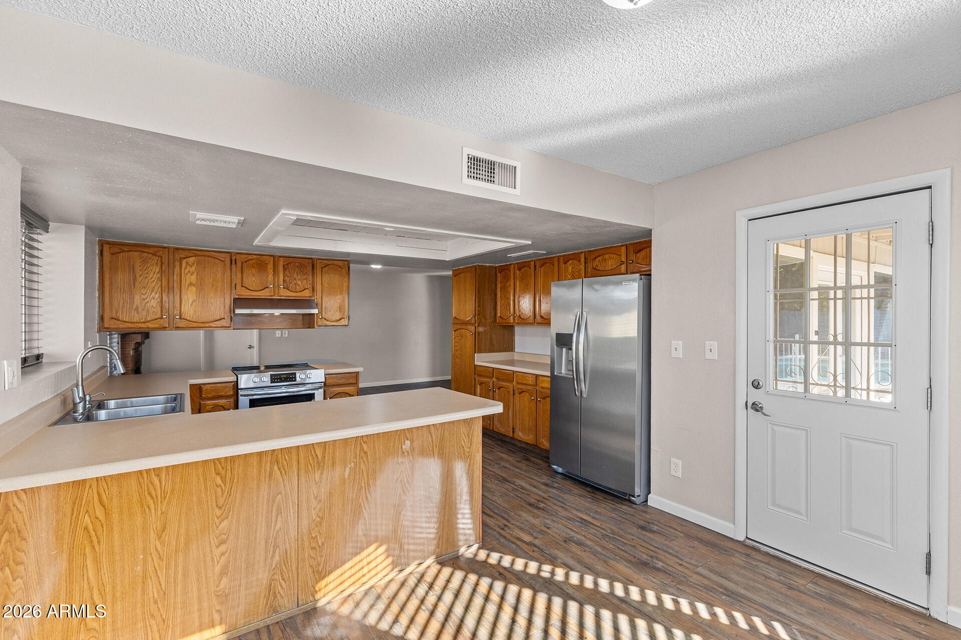 7267 West Charter Oak Road Peoria, AZ 85381 - Photo 24 of 45 a kitchen with stainless steel appliances granite countertop a refrigerator a sink a stove and island