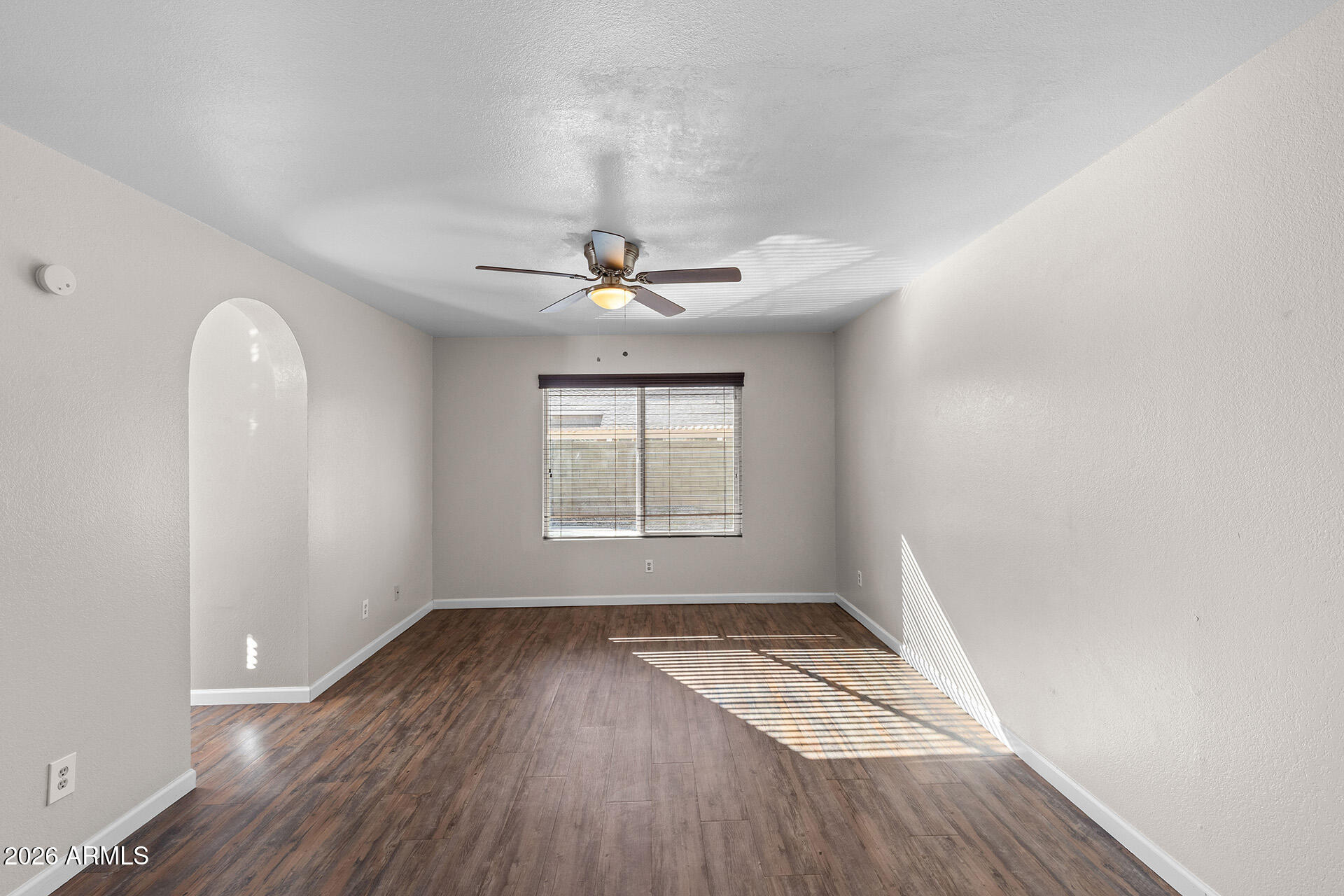 7267 West Charter Oak Road Peoria, AZ 85381 - Photo 31 of 45 an empty room with wooden floor fan and windows