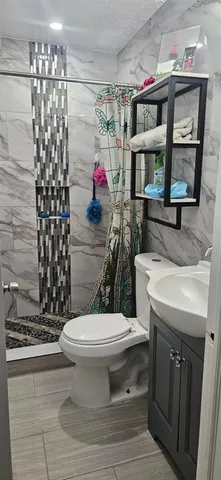 a bathroom with a sink toilet and shower