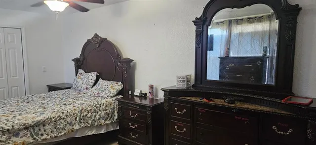 a bedroom with a bed and a dresser with mirror