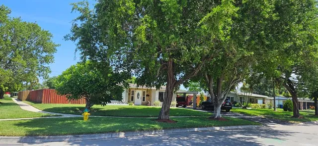 a front view of a house with a yard and trees