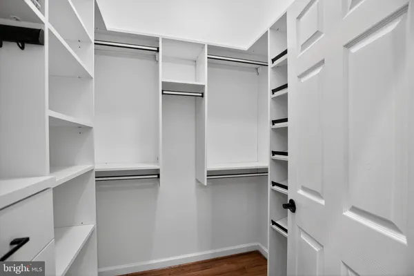a view of walk in closet with empty racks