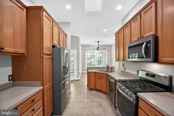 a kitchen with stainless steel appliances granite countertop a stove a sink and a refrigerator