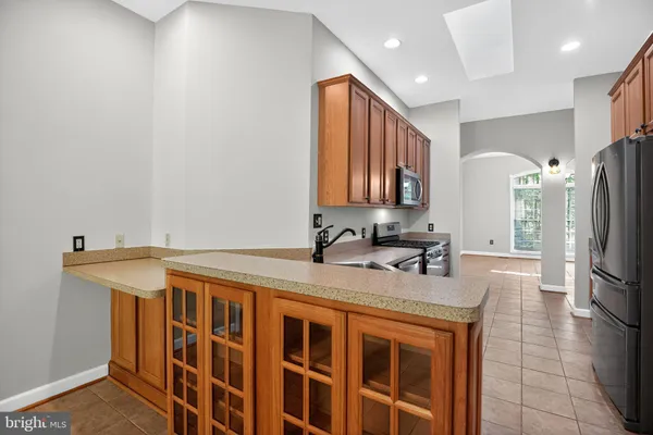 a kitchen with stainless steel appliances granite countertop a sink refrigerator and cabinets
