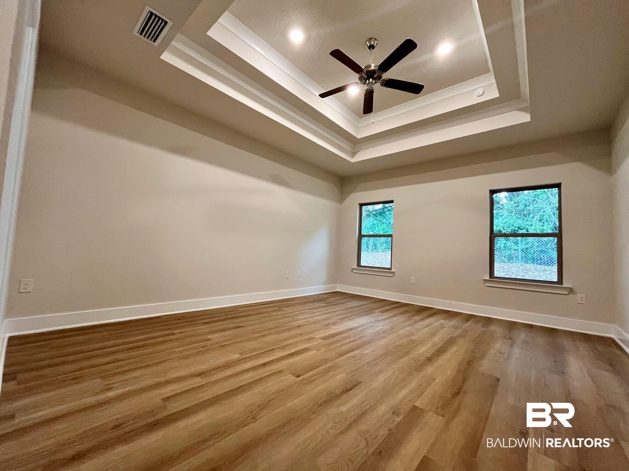 330 Barndling Street Fairhope, AL 36532 - Photo 14 of 31 Empty room featuring hardwood / wood-style floors, ceiling fan, and a raised ceiling