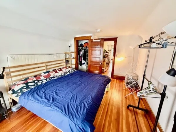 a bed sitting in a bedroom next to a window