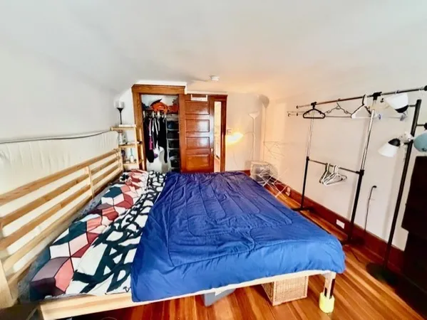 a bed sitting in a bedroom next to a window