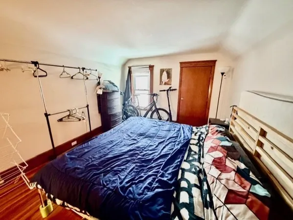 a bed sitting in a bedroom next to a window
