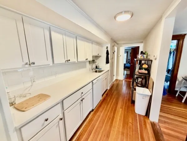 a view of a kitchen with wooden floor and staircase