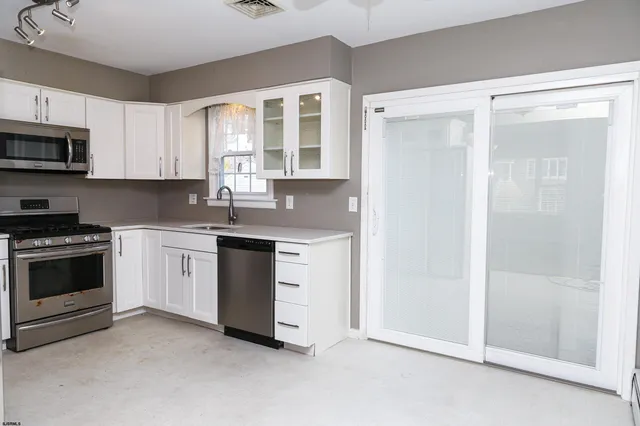 a kitchen with granite countertop white cabinets and white appliances