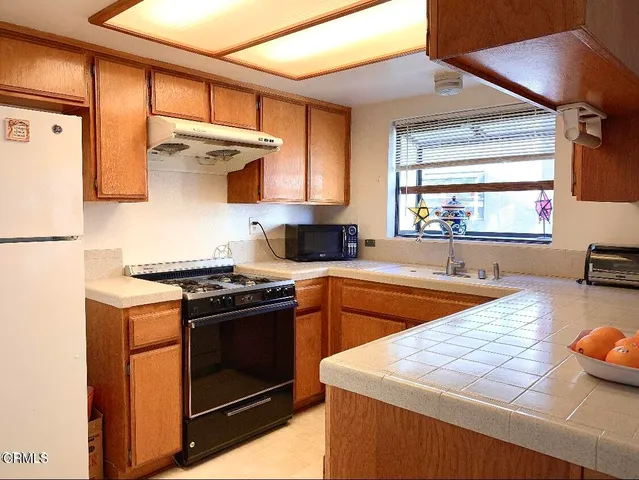 a kitchen with stainless steel appliances a stove a sink and a refrigerator