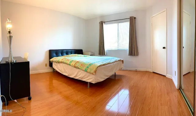 a bedroom with a bed and wooden floor