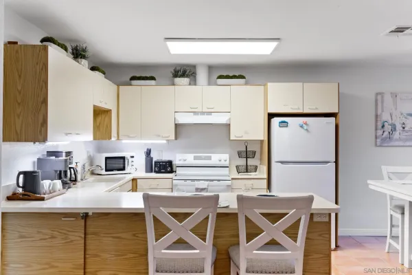 a kitchen with stainless steel appliances granite countertop a sink refrigerator and cabinets