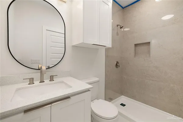 a bathroom with a sink a toilet and a mirror