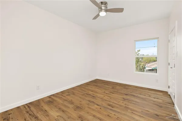 an empty room with a window and wooden floor