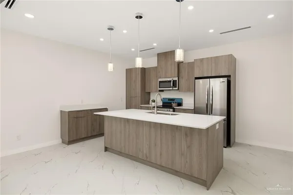 a large kitchen with a large counter top appliances and cabinets