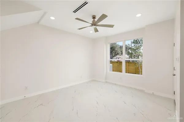 an empty room with a window and ceiling fan