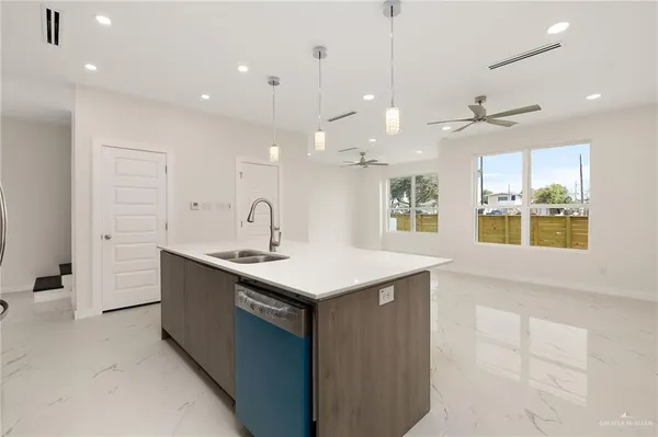 a kitchen with a sink a counter space appliances and cabinets