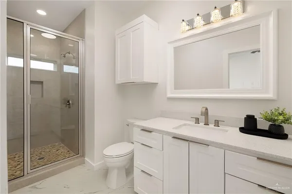 a bathroom with a sink a toilet and shower