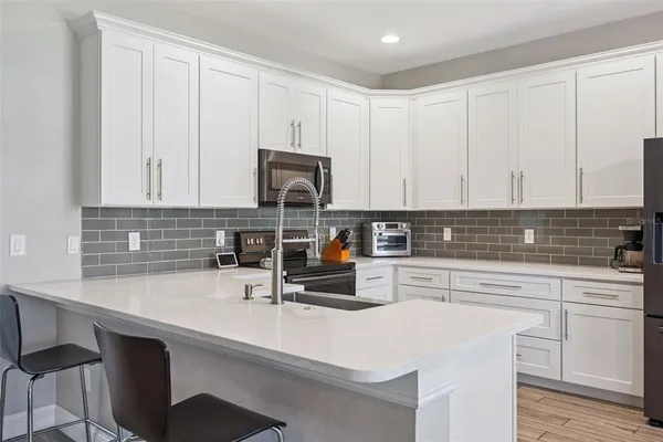 a kitchen with appliances a sink cabinets and a window