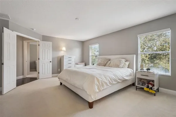 a spacious bedroom with a bed a table and large window
