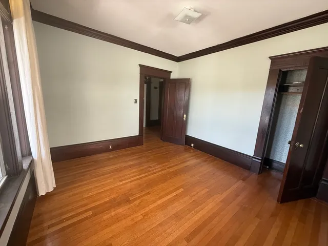 an empty room with wooden floor and a window