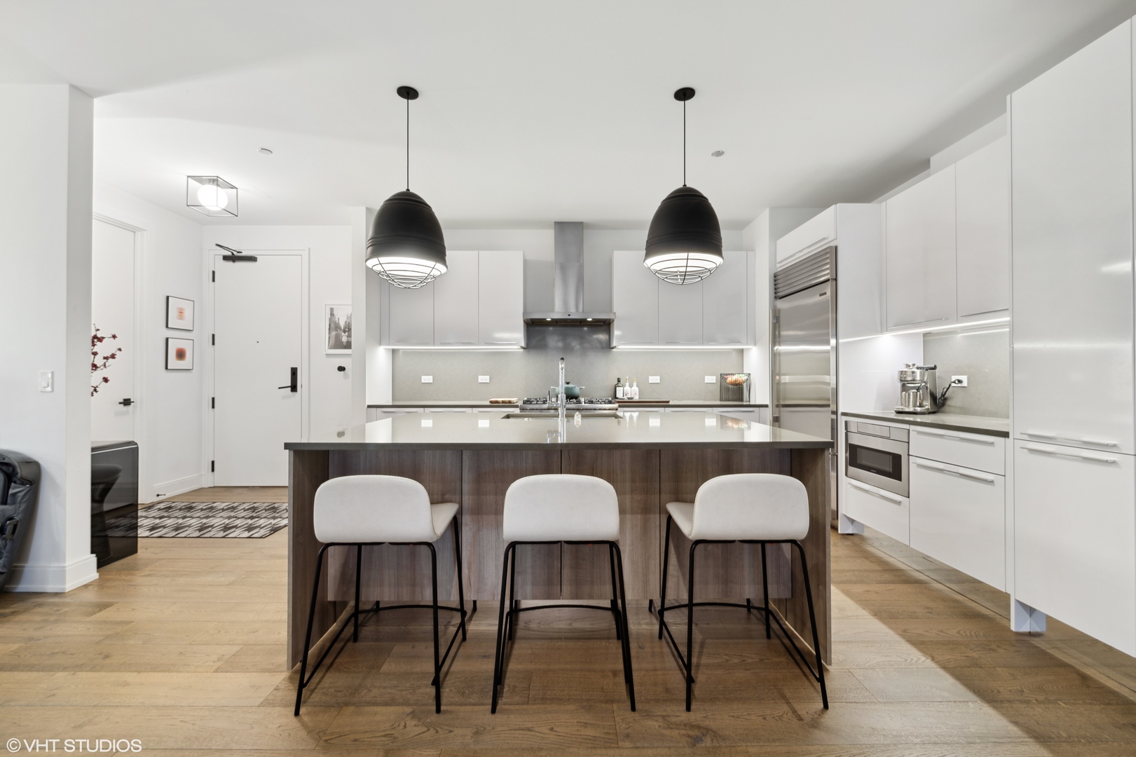 111 South Peoria Street, Unit 503 Chicago, IL 60607 - Photo 7 of 29 a kitchen with stainless steel appliances granite countertop a dining table chairs sink and white cabinets