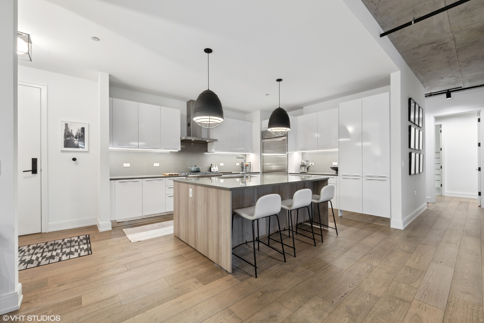 111 South Peoria Street, Unit 503 Chicago, IL 60607 - Photo 8 of 29 a kitchen with kitchen island granite countertop wooden floors and white cabinets