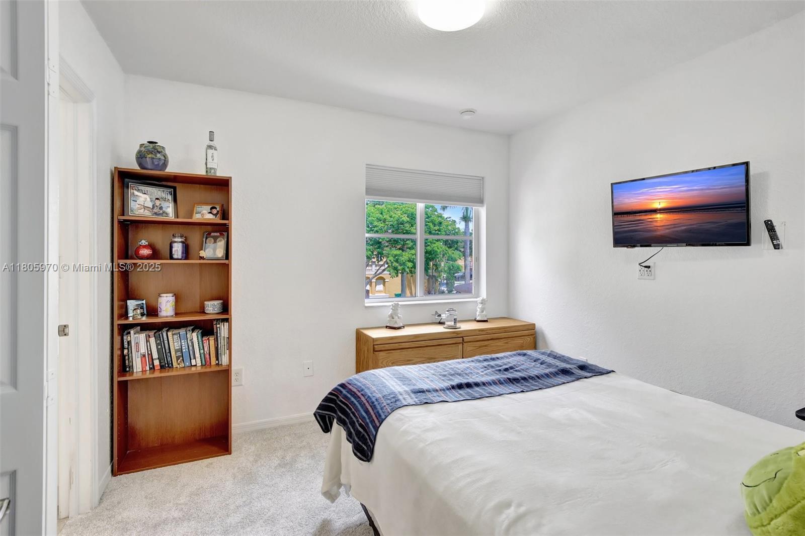 8999 Southwest 18th Street, Unit 1401 Miramar, FL 33025 - Photo 20 of 51 a bedroom with a bed and a flat screen tv