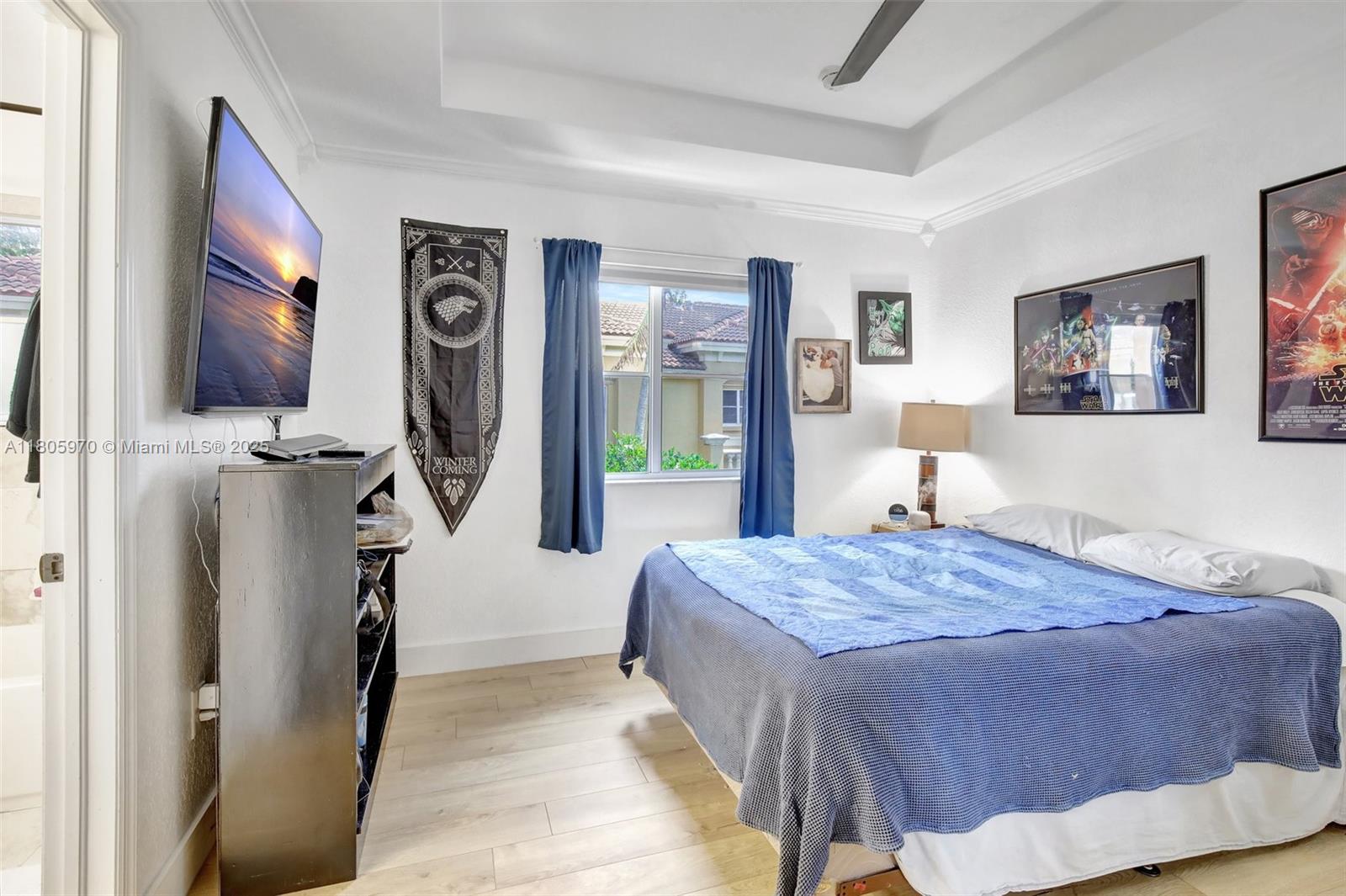 8999 Southwest 18th Street, Unit 1401 Miramar, FL 33025 - Photo 29 of 51 a bedroom with a bed and a flat screen tv